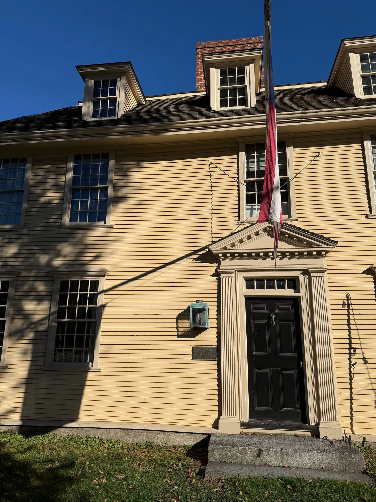 Buckman Tavern, a yellow colonial building with a flag, in Lexington