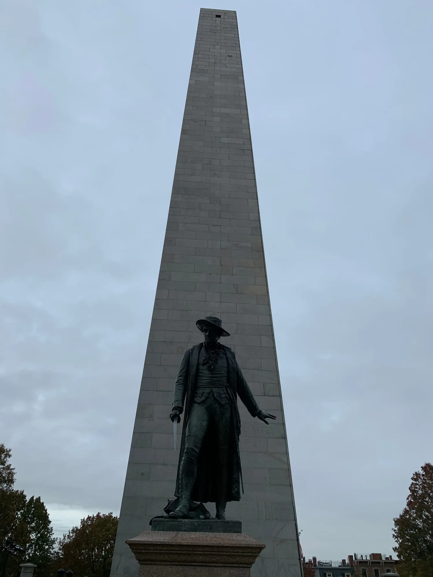 The granite Bunker Hill Monument obelisk with a bronze statue in front