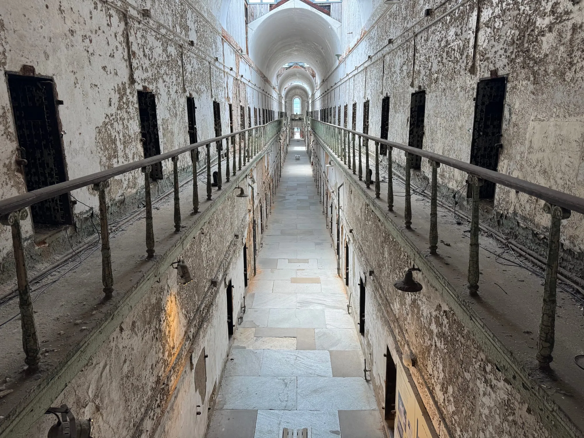 A long, crumbling cellblock corridor at Eastern State Penitentiary
