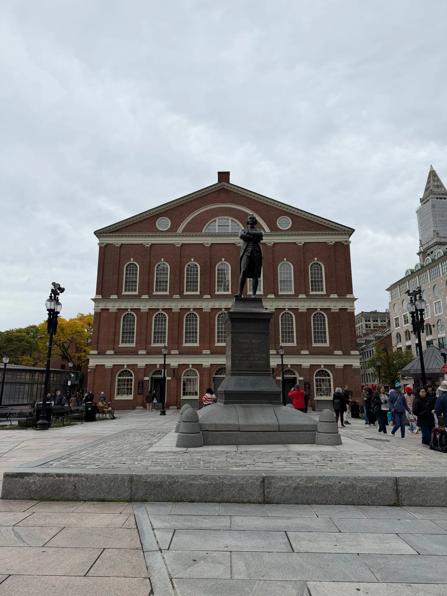 Faneuil Hall's red brick facade and cupola, with the Sam Adams statue out front