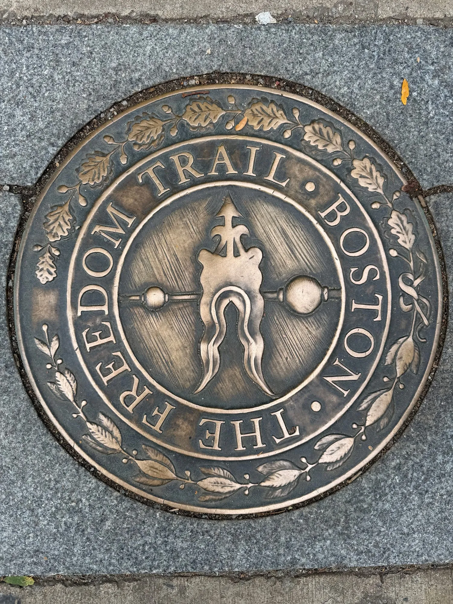 A bronze Freedom Trail medallion set into the sidewalk
