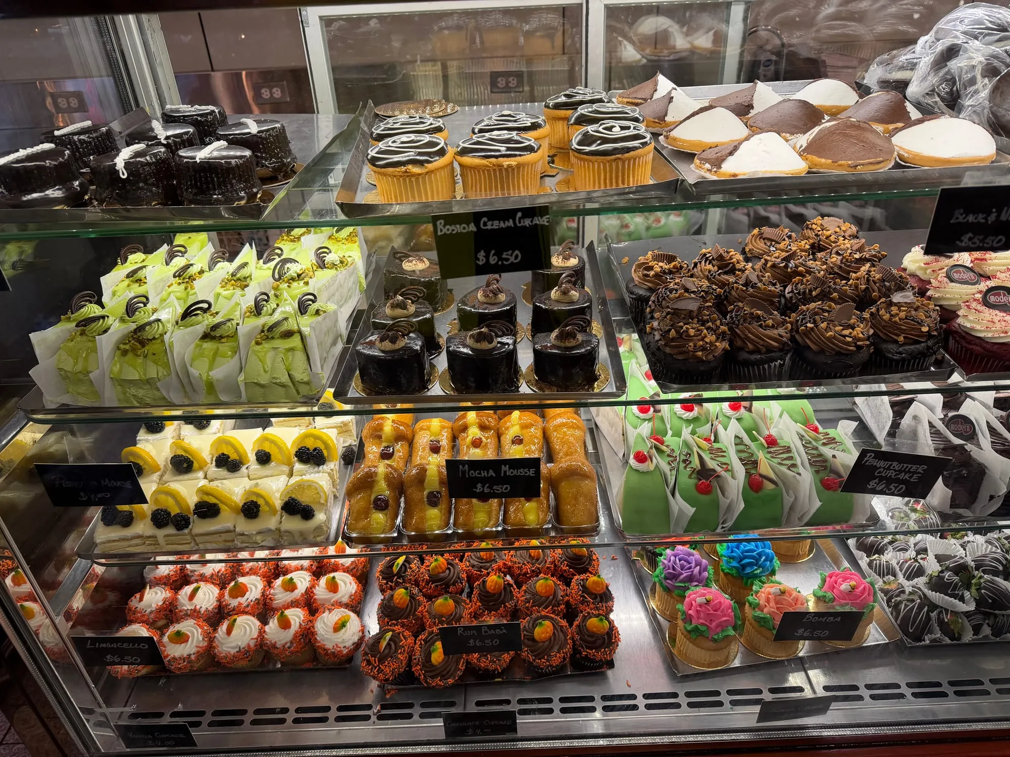 A glass case full of pastries and cannoli at Modern Pastry