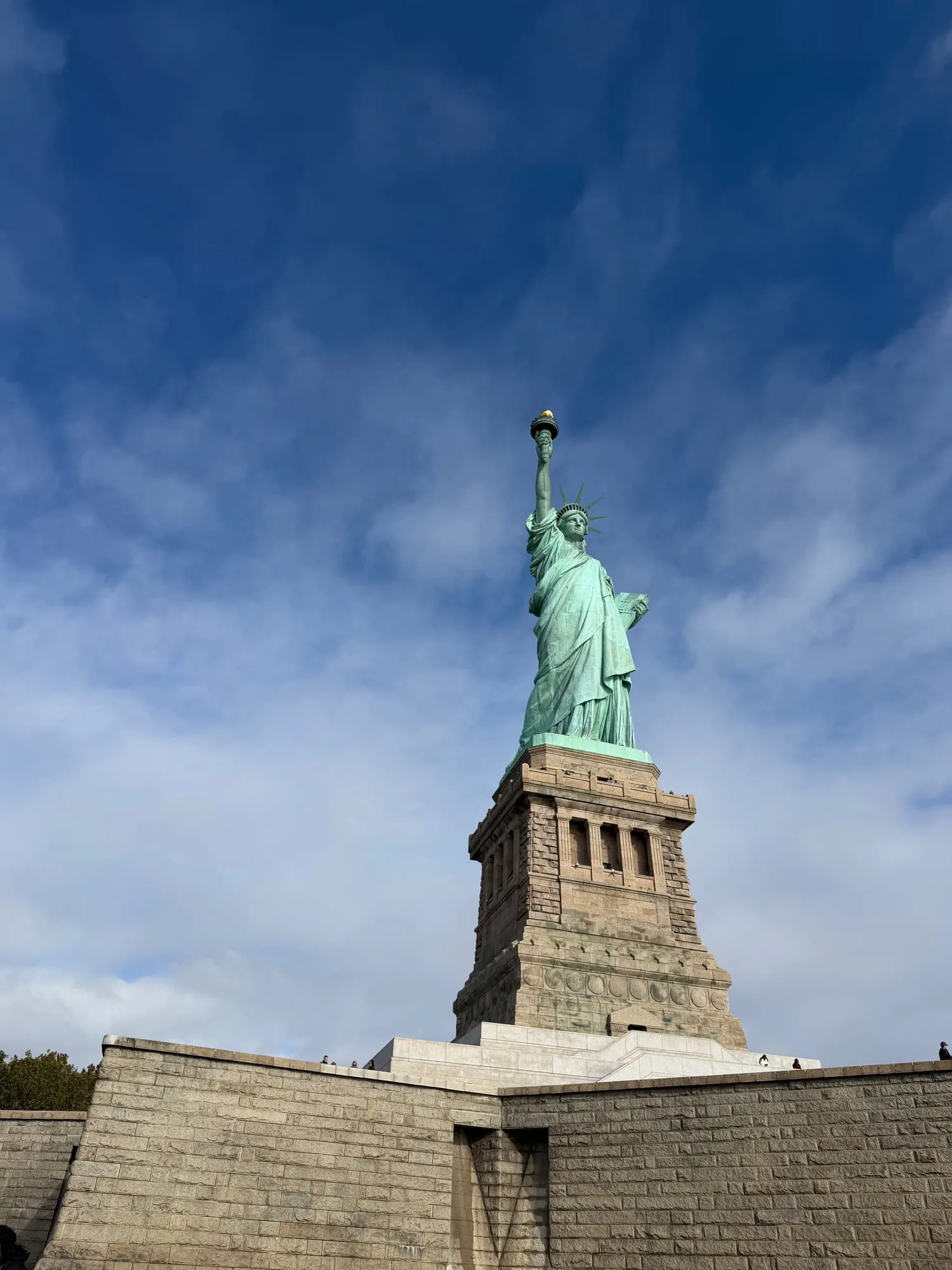 The Statue of Liberty on her pedestal against a deep blue sky